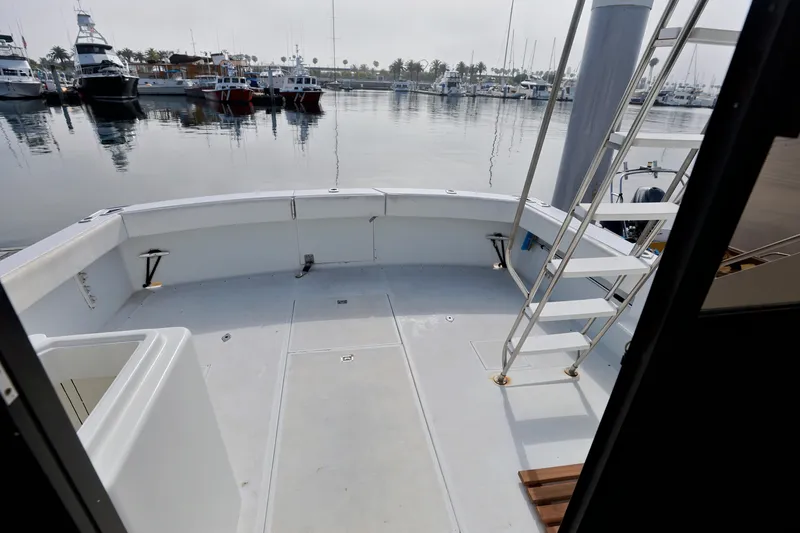 1980 Pacifica 41 Sportfisher boat deck with marina view, featuring ladder and spacious layout.