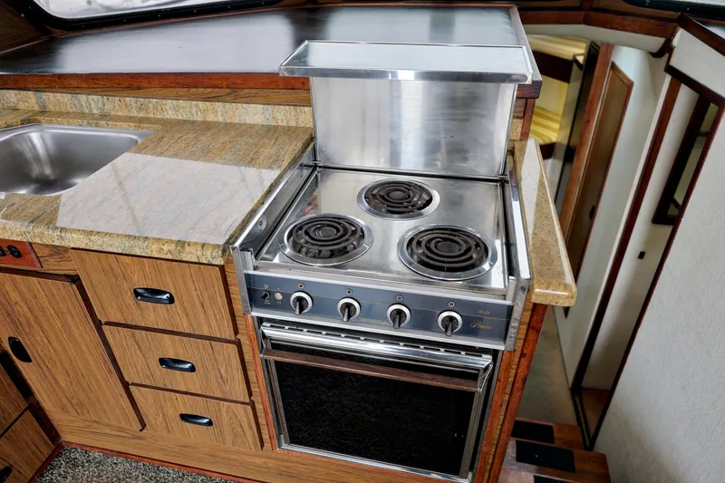 Kitchen area of 1980 Pacifica 41 Sportfisher with stove and sink.