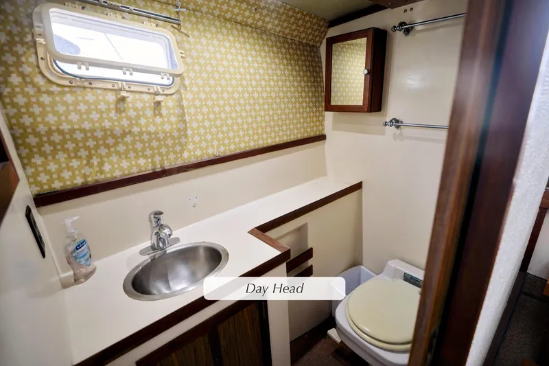 1980 Pacifica 41 Sportfisher bathroom with sink, toilet, and patterned wallpaper.