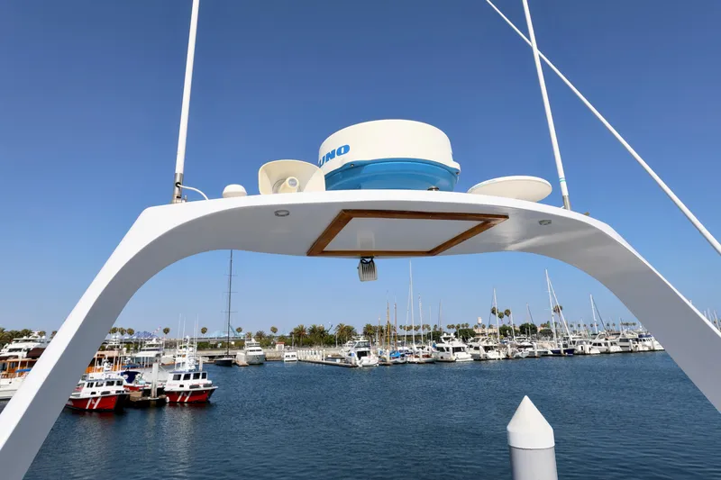 1980 Pacifica 41 Sportfisher boat in marina, clear sky, radar equipment visible.