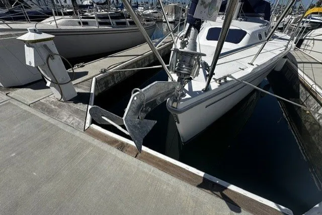 Catalina 320 sailboat from 2000 docked at a marina, featuring a prominent anchor.