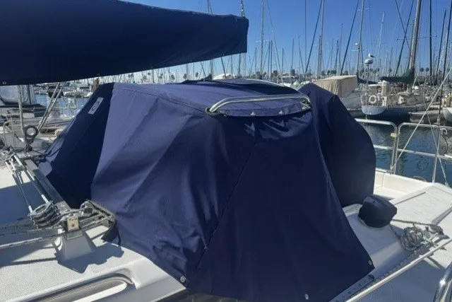 Covered 2000 Catalina 320 sailboat docked in a marina with blue canvas.