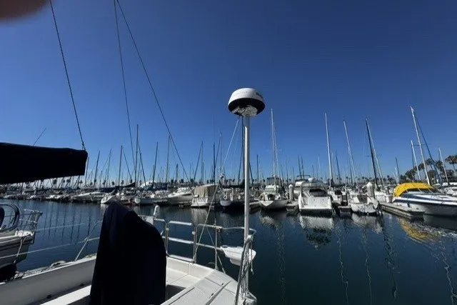 Marina view from a 2000 Catalina 320 sailboat, with numerous boats docked under a clear blue sky.