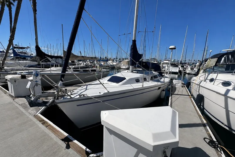 2000 Catalina 320 sailboat docked at a marina under clear blue skies.