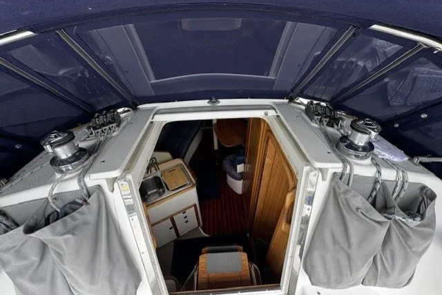 Interior view of a 2000 Catalina 320 sailboat, showcasing cabin entrance and seating area.