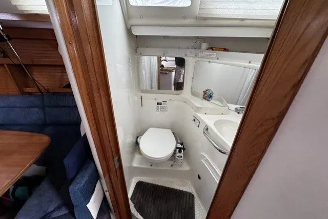 Compact bathroom in a 2000 Catalina 320 sailboat, featuring a toilet and sink.