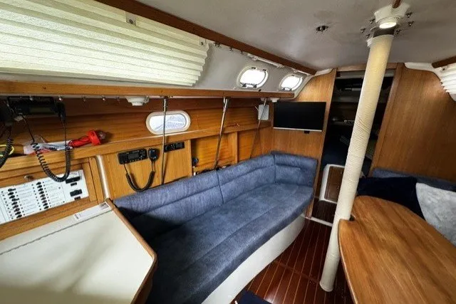 Interior of a 2000 Catalina 320 sailboat with blue seating and wooden accents.