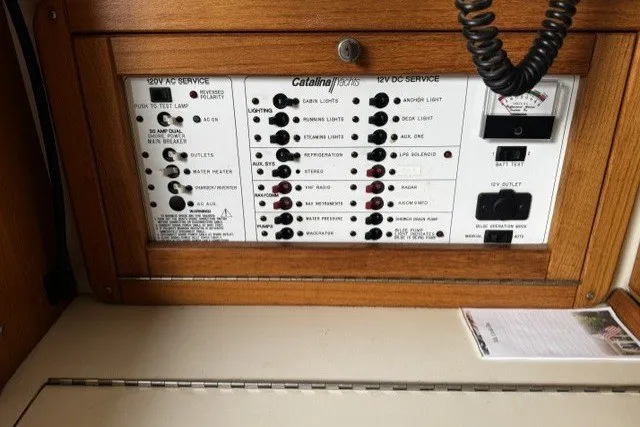 Electrical panel of a 2000 Catalina 320 sailboat, featuring AC and DC service controls.