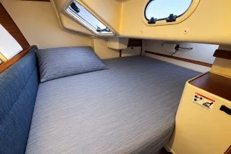 Cozy cabin interior of a 2000 Catalina 320 sailboat with a comfortable bed.