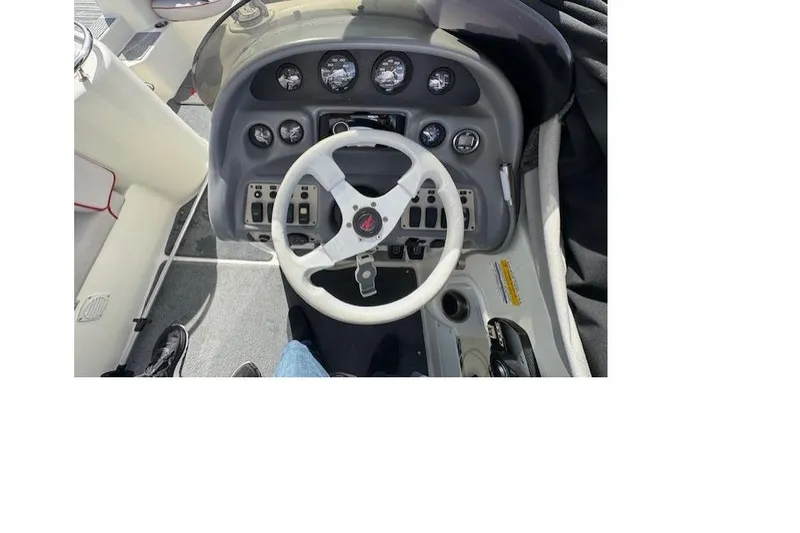 1997 Sea Ray 240 Sundeck dashboard with steering wheel and instrument panel.