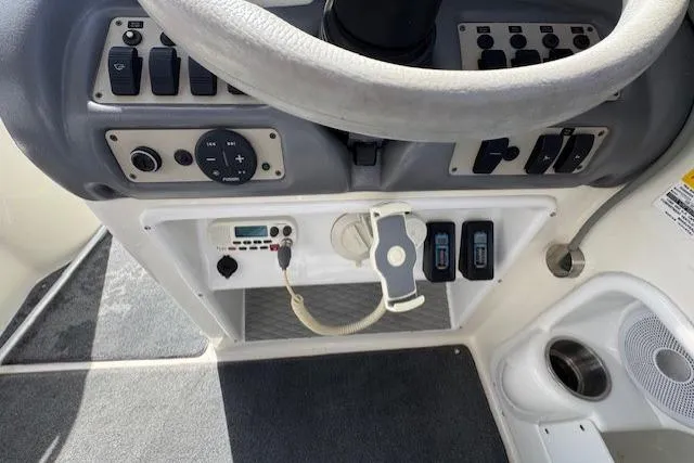 Control panel of a 1997 Sea Ray 240 Sundeck boat, featuring steering wheel and switches.
