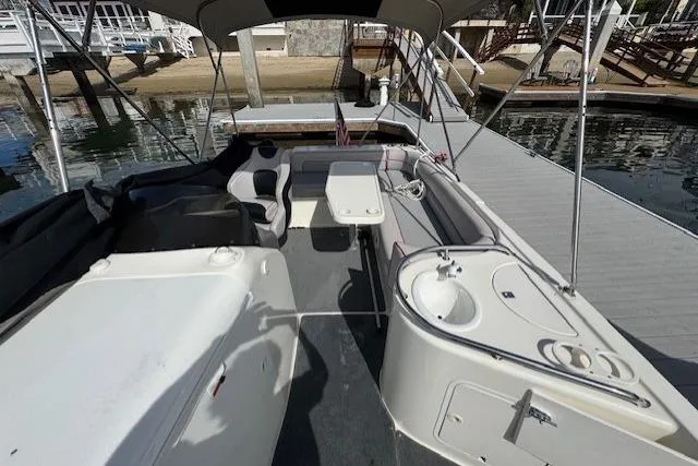 1997 Sea Ray 240 Sundeck boat interior with seating, table, and sink by the dock.