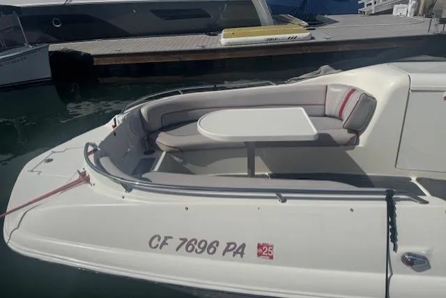 1997 Sea Ray 240 Sundeck boat with seating and table, docked at marina.