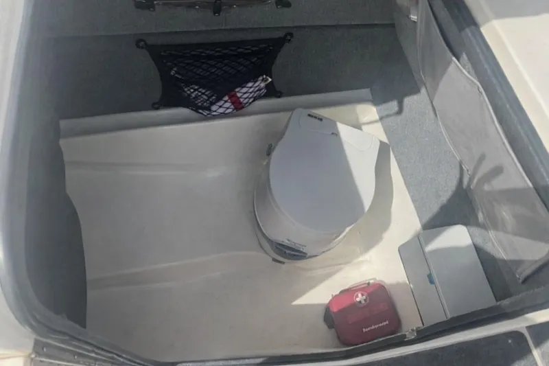 Interior of 1997 Sea Ray 240 Sundeck with portable toilet.