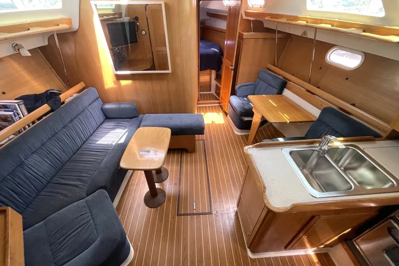 Interior of a 2004 Catalina 350 sailboat with cozy seating and wooden finishes.