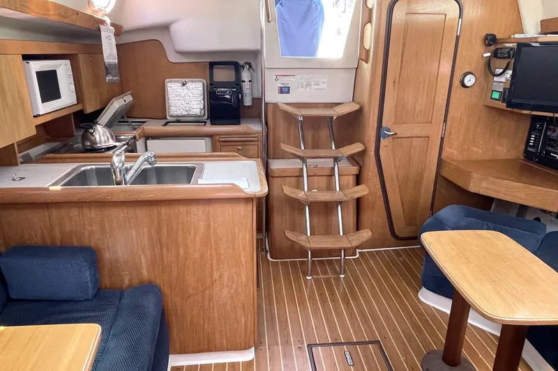 Interior of a 2004 Catalina 350 sailboat with kitchen and seating area.