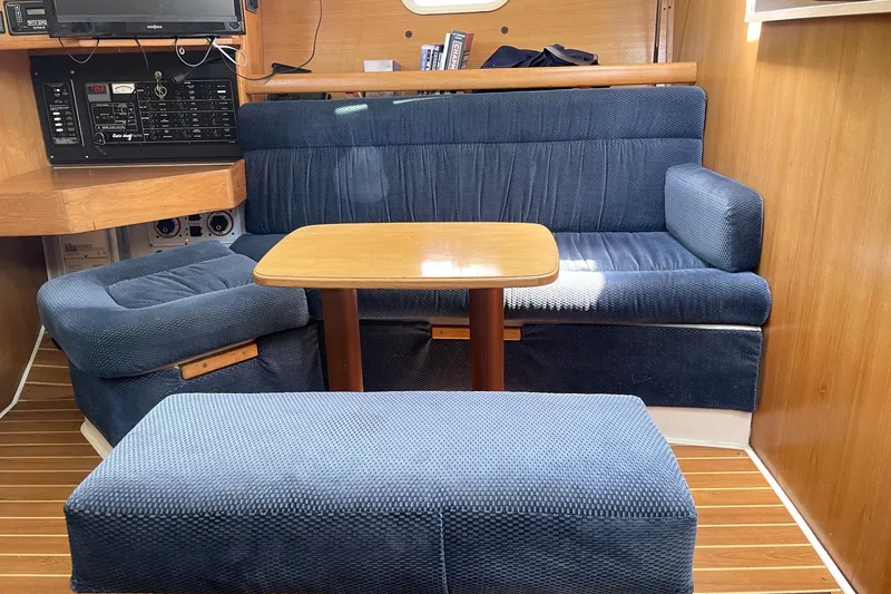 Interior of a 2004 Catalina 350 sailboat with blue seating and wooden table.