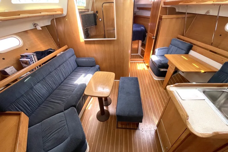 Interior of a 2004 Catalina 350 sailboat with cozy seating and wooden finishes.
