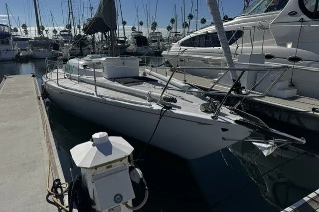 Sailboat docked in marina, 1973 Custom BILL LEE 40, surrounded by other boats.