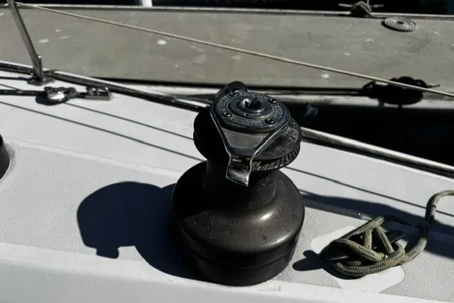 Winch on 1973 Custom BILL LEE 40 sailboat deck, with rope and railing visible.