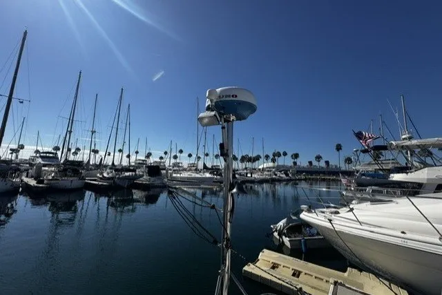 Marina with sailboats and yachts under clear blue sky, featuring a 1973 Custom BILL LEE 40.
