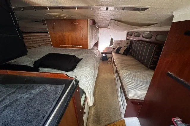 Interior of a 1973 Custom BILL LEE 40 sailboat with cozy sleeping area and wooden accents.