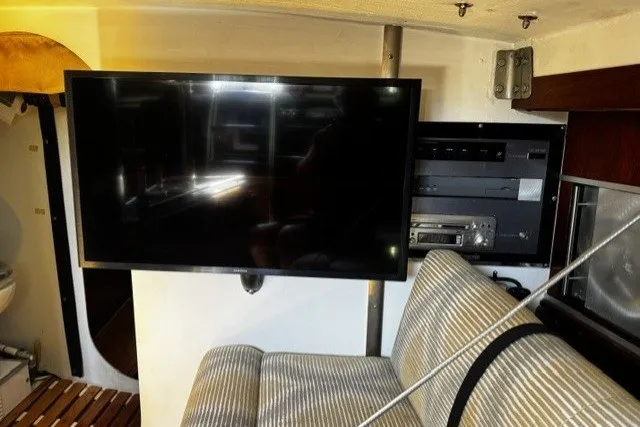 Interior of 1973 Custom BILL LEE 40 yacht with TV and striped seating.