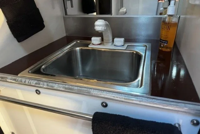 Stainless steel sink in 1973 Custom BILL LEE 40 yacht bathroom with soap dispenser.