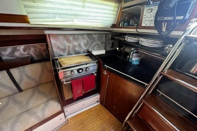 Interior of a 1973 Custom BILL LEE 40 yacht, featuring a compact kitchen area.
