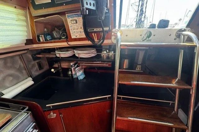 Interior of a 1973 Custom BILL LEE 40 yacht with kitchen and wooden stairs.