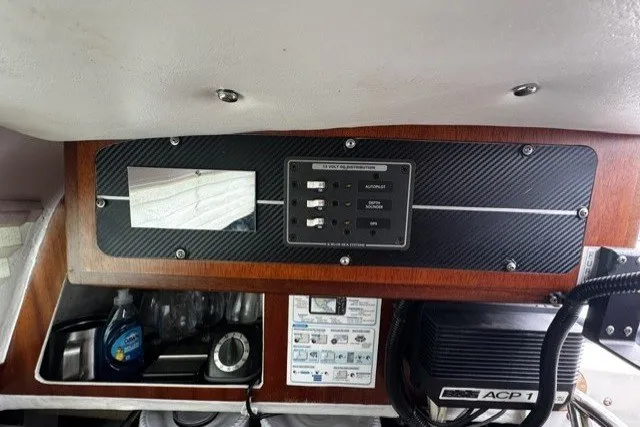 Control panel inside a 1973 Custom BILL LEE 40 yacht, featuring switches and storage compartments.