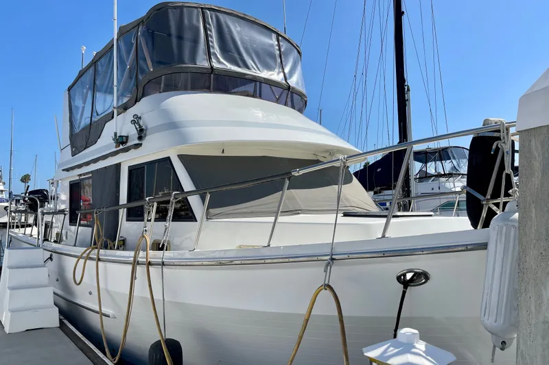 1985 CHB 42 yacht docked at marina, featuring upper deck enclosure.