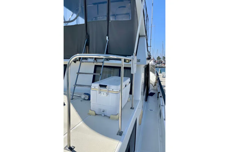 1985 CHB 42 yacht deck with ladder and cooler, docked at marina.
