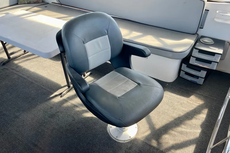 Captain's chair on 1985 CHB 42 boat, with table and seating area.