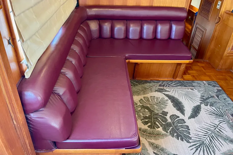 Luxurious maroon leather seating in a 1985 CHB 42 yacht interior.