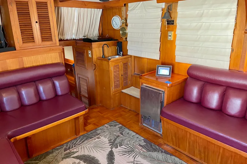 Interior of a 1985 CHB 42 boat with wood paneling and maroon seating.