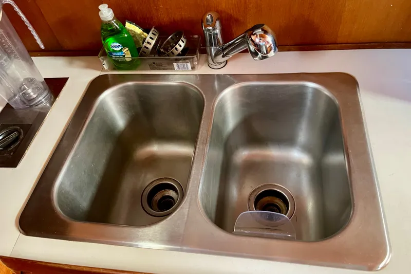 Double stainless steel sink with faucet and dish soap on a CHB 42, 1985 model.