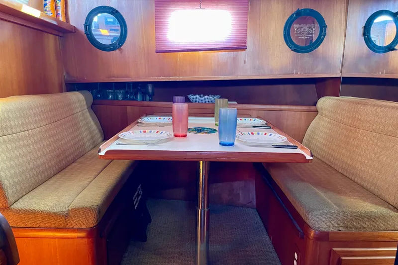 Cozy dining area inside a 1985 CHB 42 boat, featuring a table set for four.