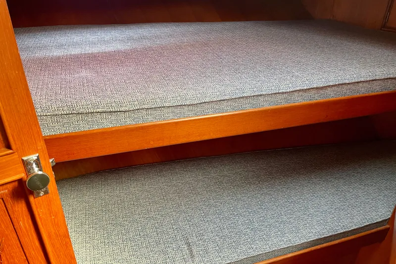 Wooden bunk beds with gray cushions in a 1985 CHB 42 boat interior.