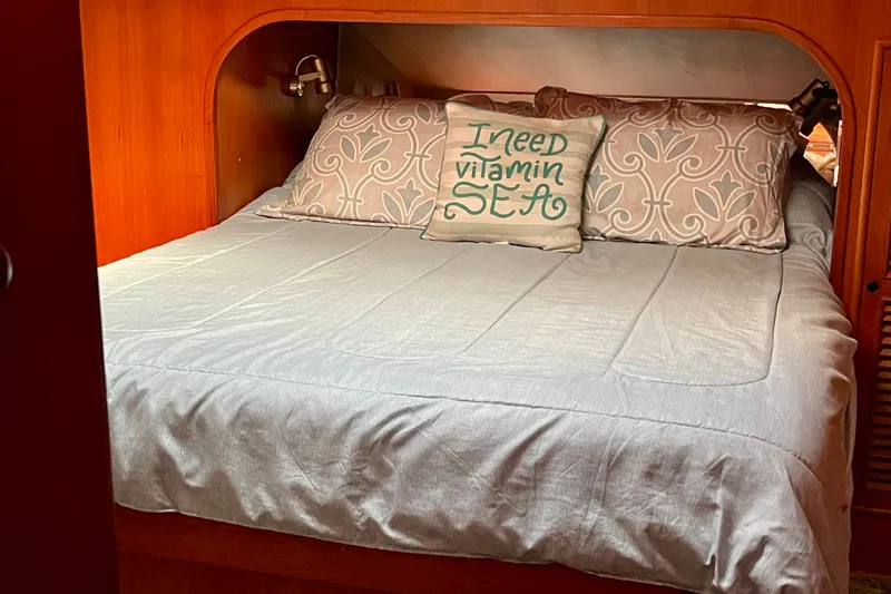 Cozy cabin bed in 1985 CHB 42 boat with decorative pillows.