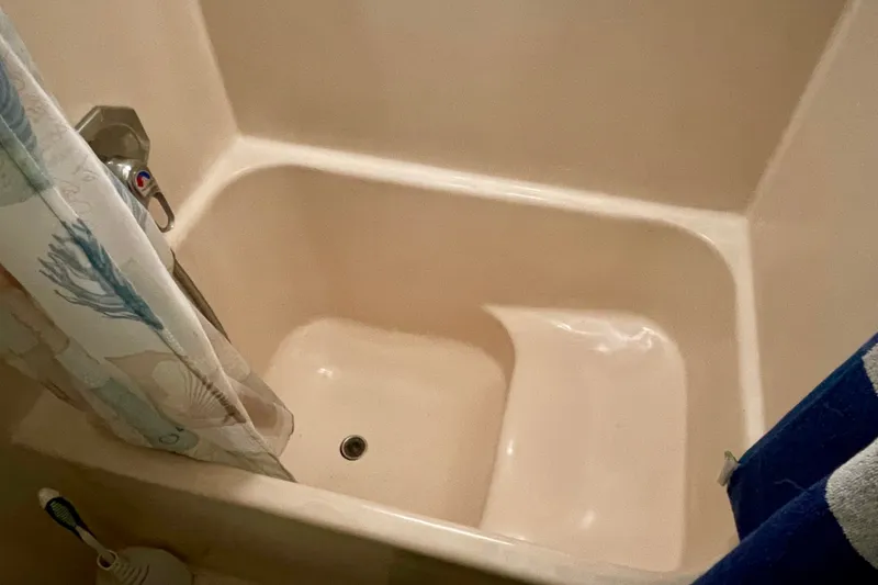 Bathtub with shower curtain and faucet in a CHB 42, 1985 model.