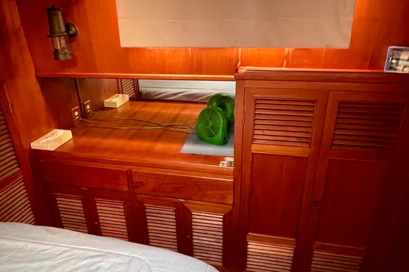 Wooden interior of 1985 CHB 42 boat cabin with fan and storage cabinets.