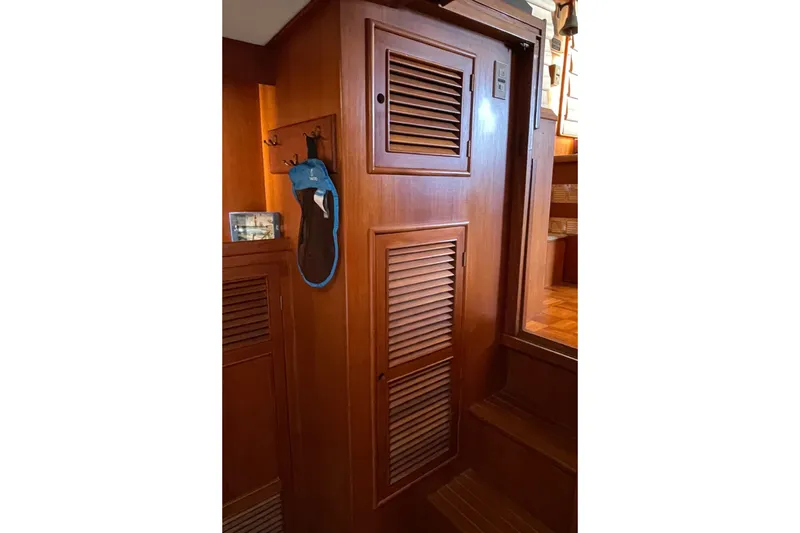 Wooden interior of 1985 CHB 42 boat with louvered doors and hanging items.