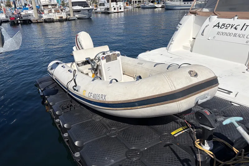 Inflatable boat docked beside 1999 Cruisers Yachts 3870 Esprit in marina.