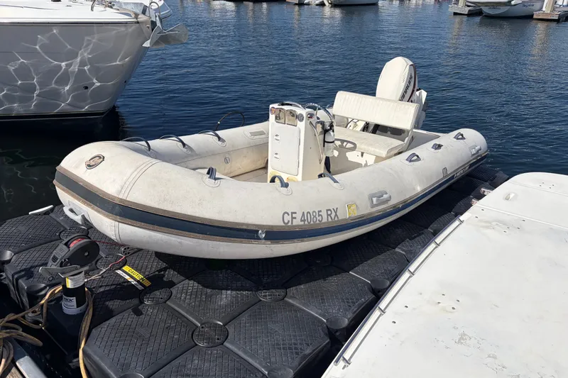 Inflatable boat docked beside a 1999 Cruisers Yachts 3870 Esprit in a marina.