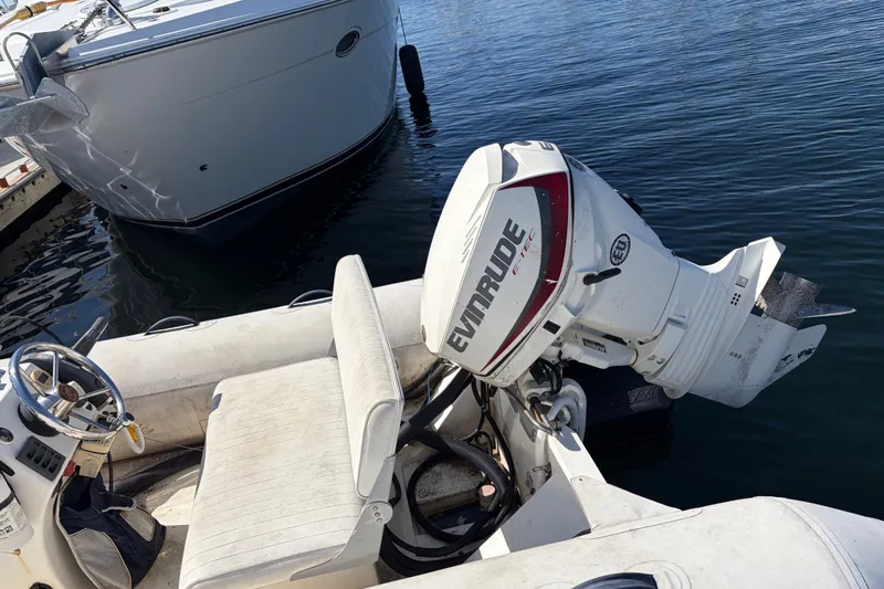 1999 Cruisers Yachts 3870 Esprit with Evinrude outboard motor docked on calm water.