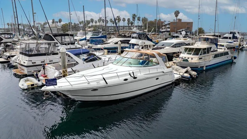1999 Cruisers Yachts 3870 Esprit docked in a marina, surrounded by other boats.