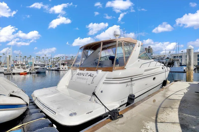 1999 Cruisers Yachts 3870 Esprit docked at marina under blue sky.