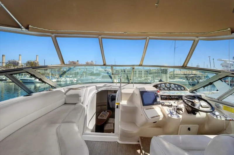 1999 Cruisers Yachts 3870 Esprit cockpit with helm, seating, and marina view.