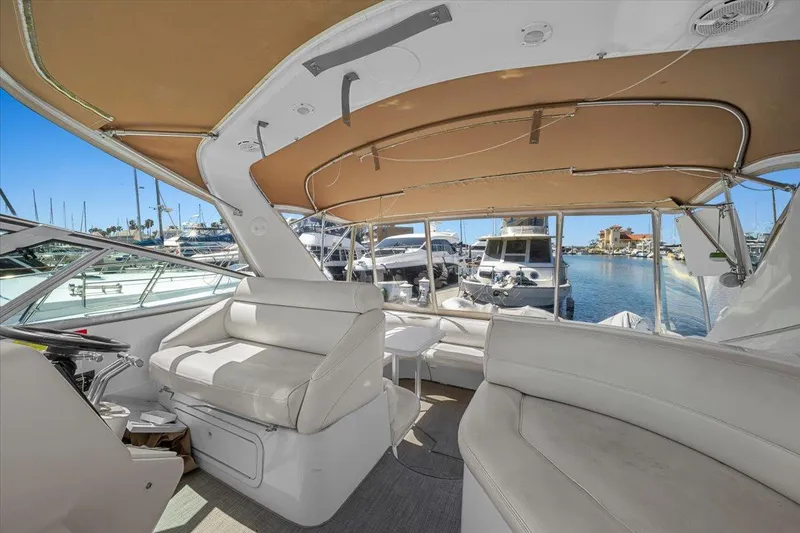1999 Cruisers Yachts 3870 Esprit interior with white seating and marina view.